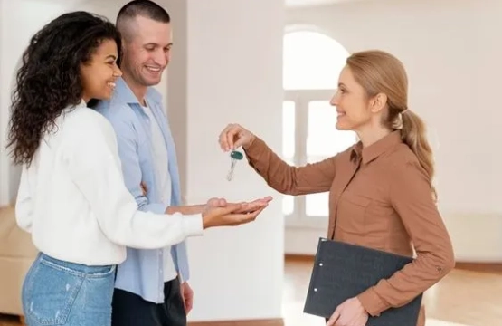 Agent immobilier remettant des clés à des locataires – Mettre en location un appartement meublé