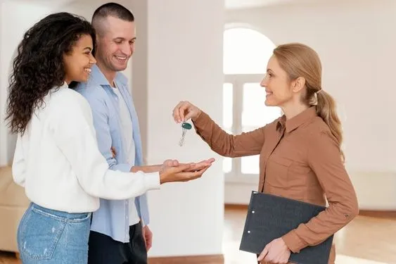 Agent immobilier remettant des clés à des locataires – Mettre en location un appartement meublé