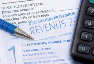 Formulaire de déclaration de revenus français avec un stylo bleu et une calculatrice.