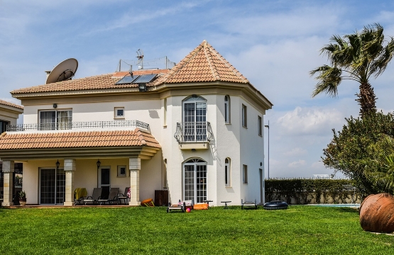 Grande résidence secondaire moderne avec toit en tuiles et jardin arboré.