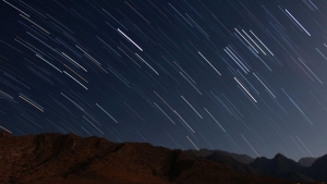 Picsum ID 683 - Gestion locative Paris, location d'appartements - Gestion locative Paris, location d'appartements Long-exposure image of star trails streaking across a dark night sky above a rocky mountain ridge.
